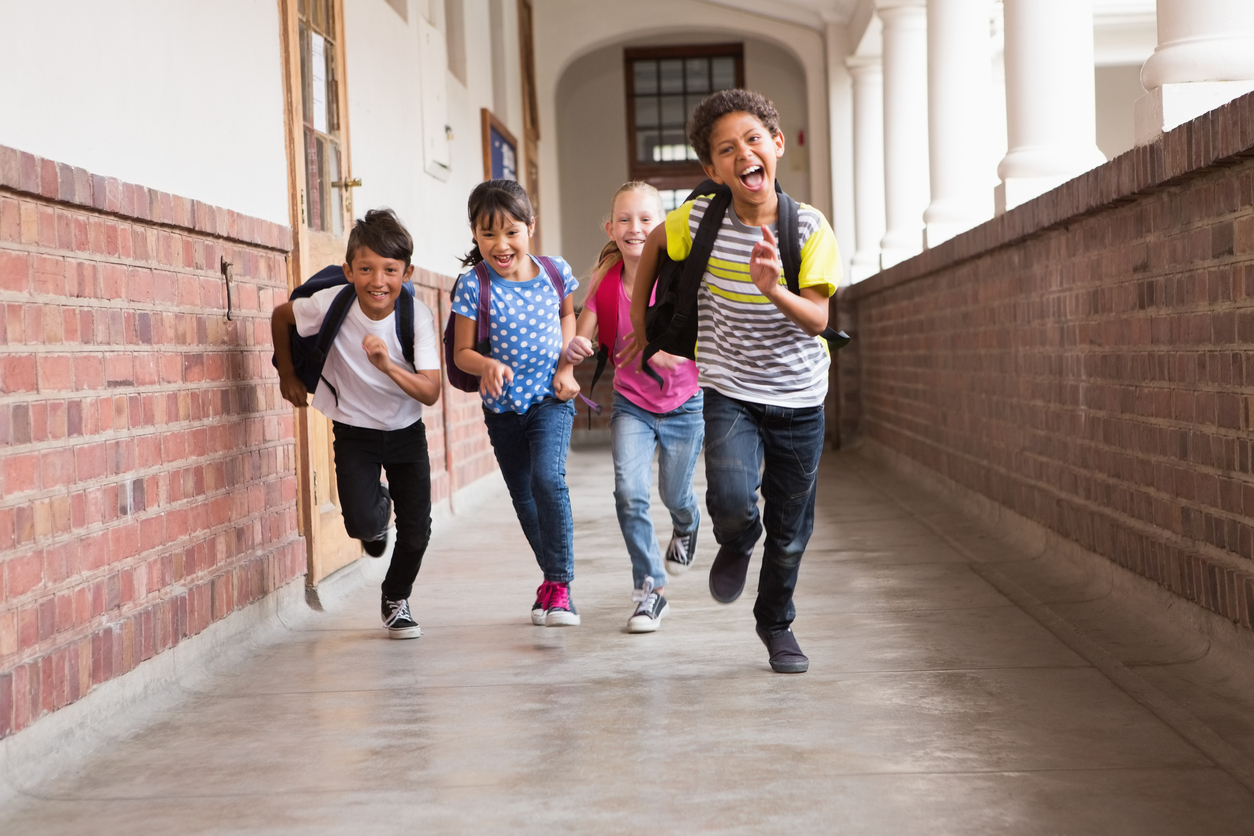 Cute pupils running down the hall at the elementary school, not worried about bedwetting.