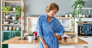 Middle age woman in bright kitchen, smiling, looking away