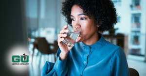 Woman sipping on water in clear glass in the middle of the night