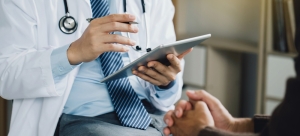 Doctor using Ipad while talking to patient