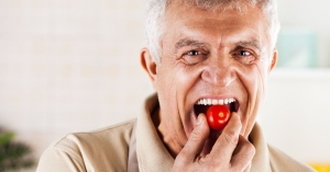 Man biting into cherry tomato