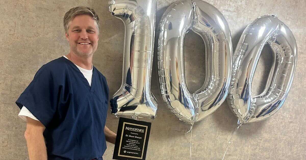 Dr. Brent Sharpe Performed 100th NanoKnife® Prostate Cancer Case while vstanding next to 100 balloons and an award