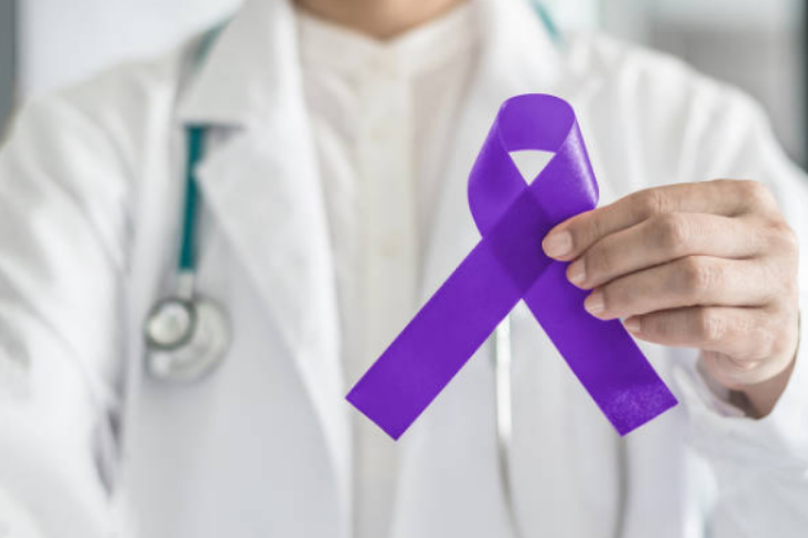 Doctor holding a purple ribbon for Testicular cancer.