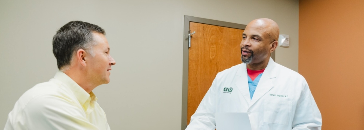 Doctor speaking with patient, patient is seated