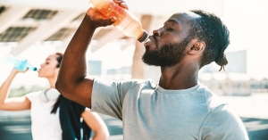Man drinking water in bottle to stay hydrated