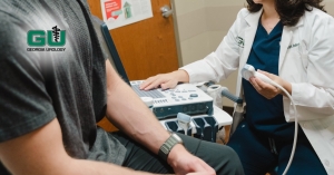 Dr. Hebert holding ultrasound transducer while patient sits on examination table