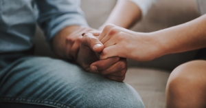 Woman holding partner's hand in supportive way