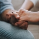 Woman holding partner's hand in supportive way