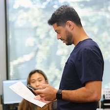 Dr. Kapadia reviewing paperwork and speaking to a nurse