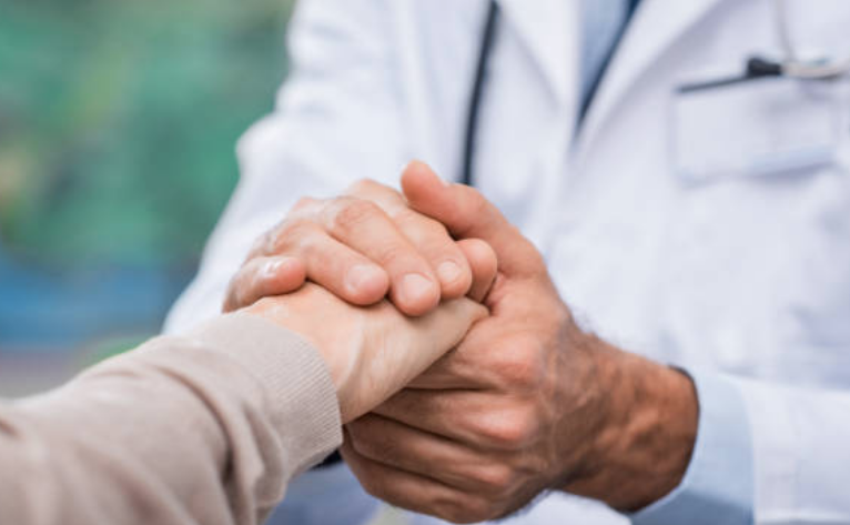 Doctor holding the hands of a patient, discussing Urolift.