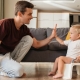 Dad and toddler son in living room, potty training child on mini toilet while hi-fiving fathe
