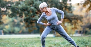Woman exercising outdoors, stretching legs in lunge position