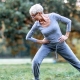 Woman exercising outdoors, stretching legs in lunge position