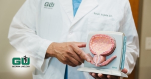 Dr. Anglade holding diagram of male bladder and pointing to it