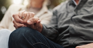 Older man and partner holding hands