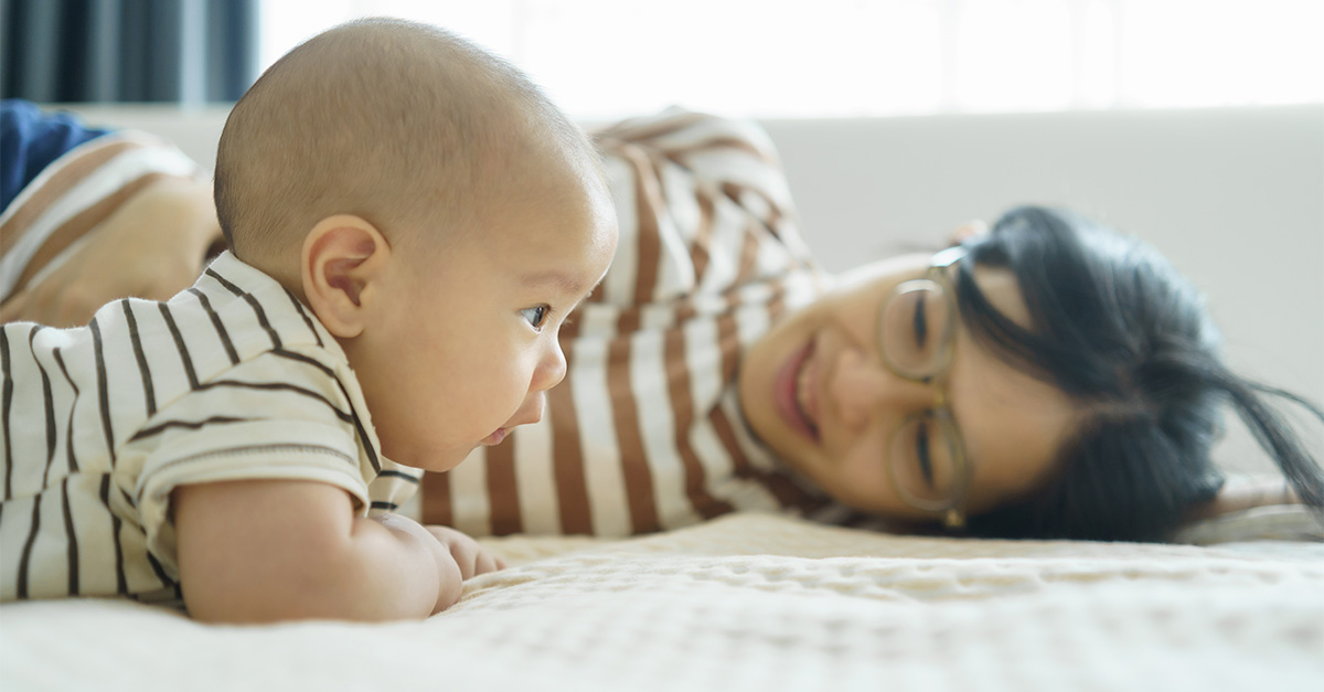 Concerned mother smiling at her newborn.