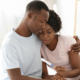 Man and woman hugging while holding pregnancy test