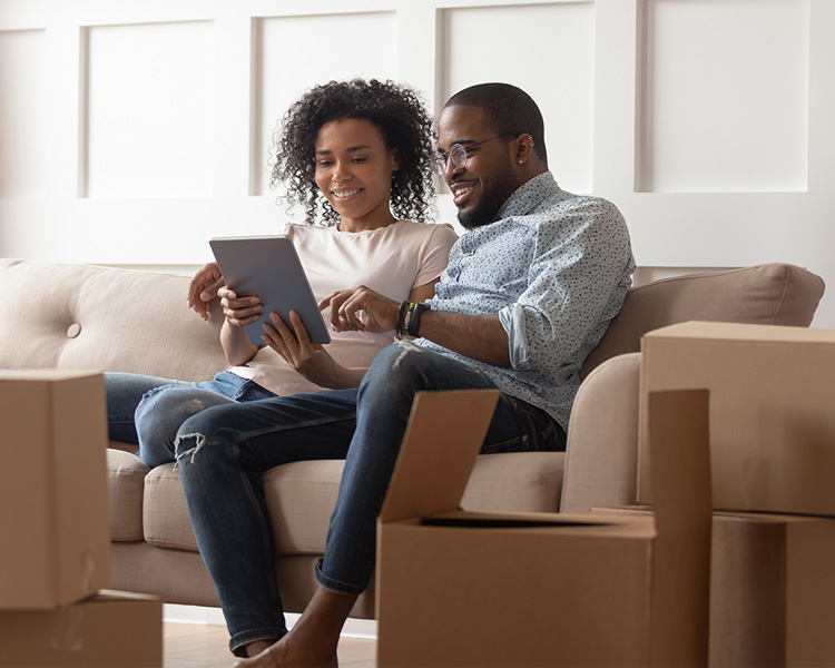 Smiling African American couple accessing the Georgia Urology patient portal on their tablet.