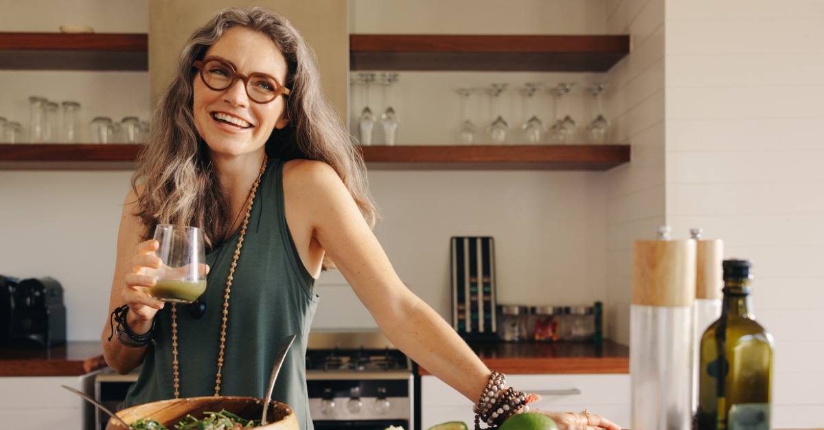 healthy senior woman smiling holding green juice