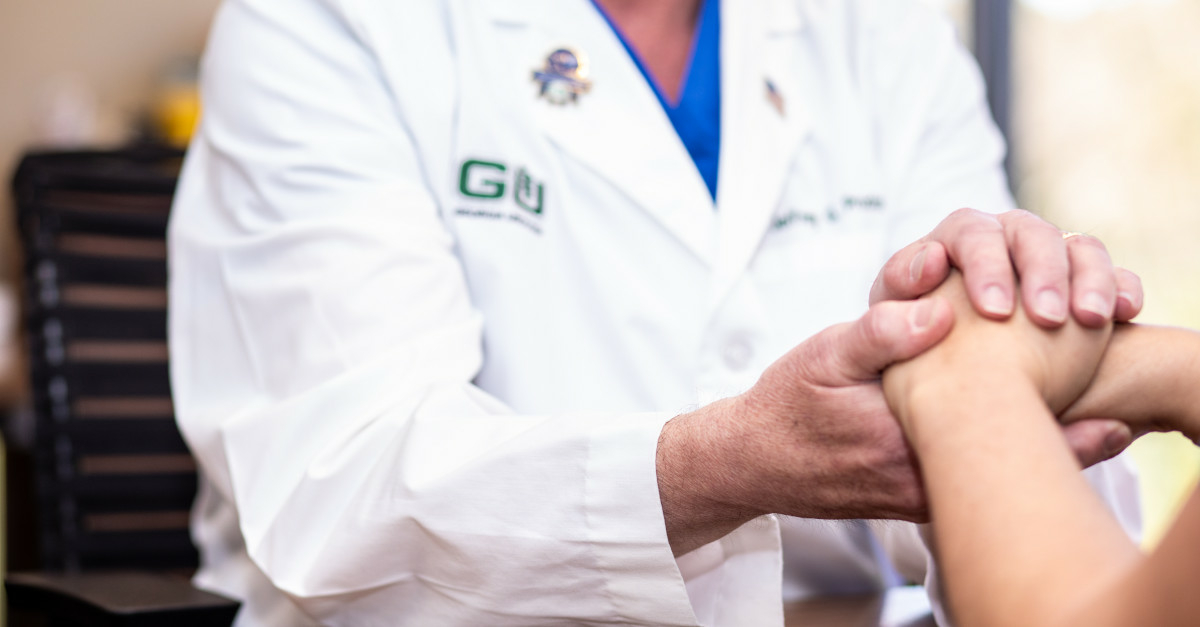 Doctor holding hands of patient