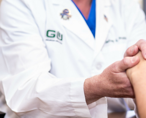 Doctor holding hands of patient