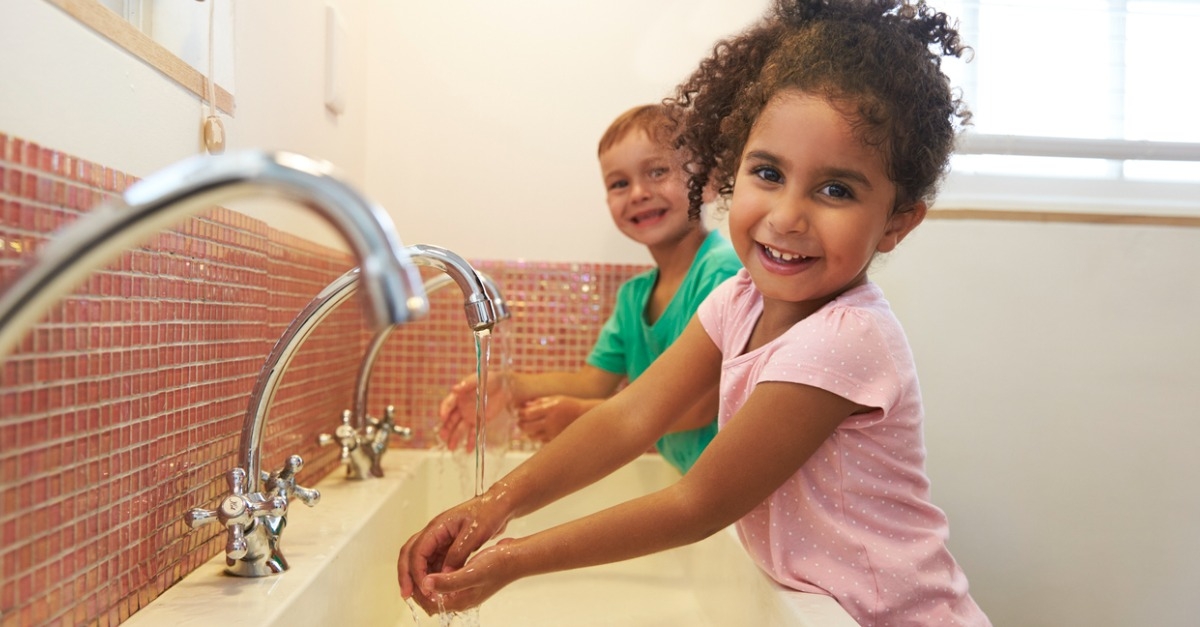 Two children at Montessori School Washing Hands In Washroom