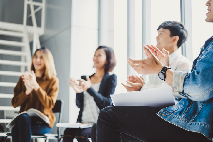 Young business people clapping hands during meeting in office for their success in business work.