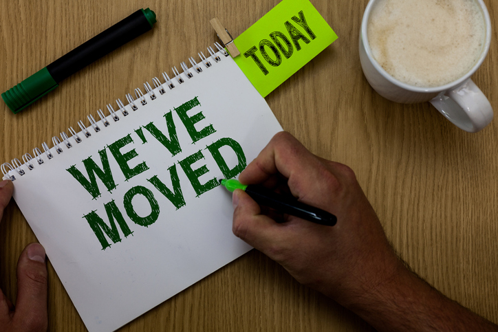 Conceptual hand writing showing Weve have Moved. Business photo showcasing going to live from place another same or different country Man holding marker notebook reminder wooden table cup coffee.