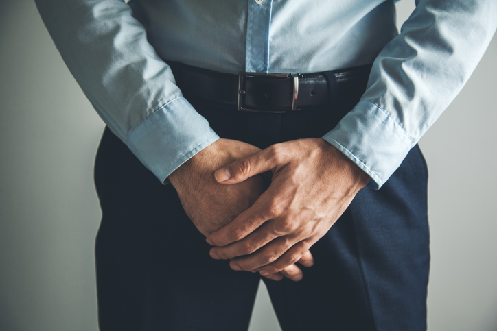 Man holding his crouch in pain from overactive bladder.