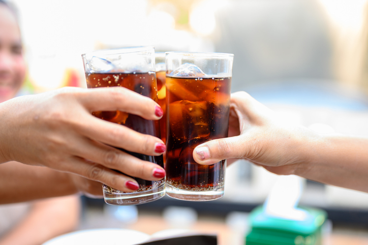 Hands holding glasses of soda