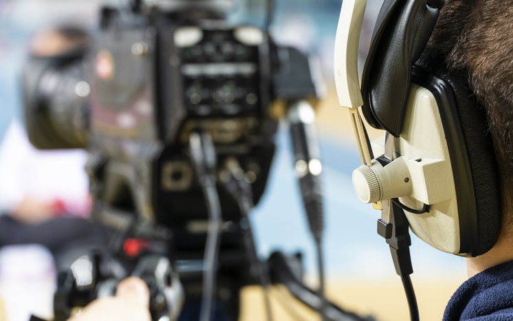 Professional cameraman with headphones with 4K camcorder in live television.