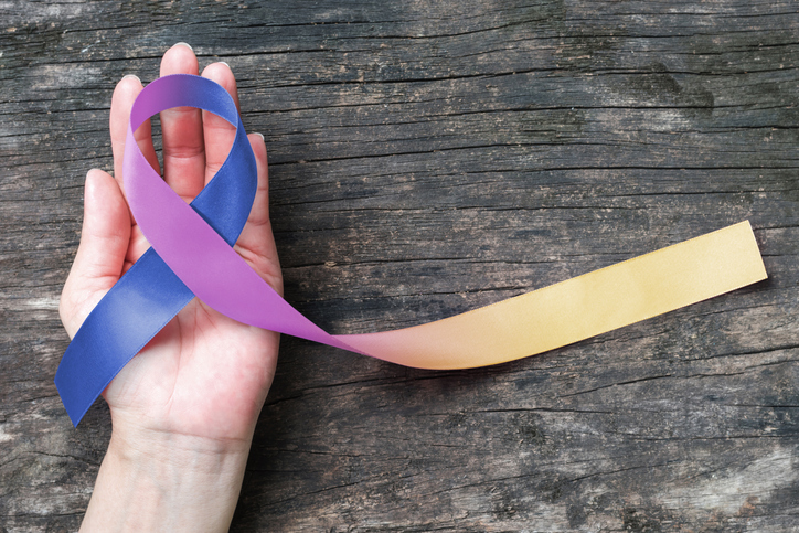 Bladder cancer awareness marigold blue purple ribbon (isolated with clipping path) symbolic color on helping hand support