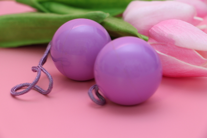 Pink vaginal balls on a pink background. Double vaginal balls. Womans health for kegel exercises. Strengthening the intimate muscles of the vagina.