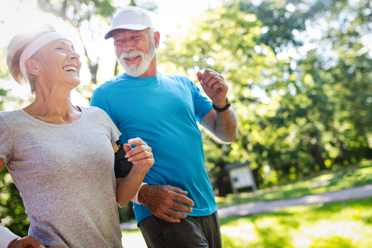 Beautiful senior couple jogging in nature living healthy.