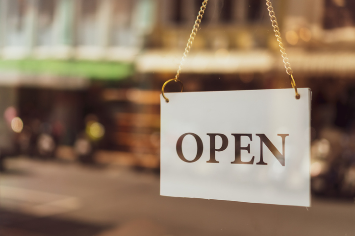 A business sign that says Open on cafe or restaurant hang on door at entrance. Vintage color tone style.