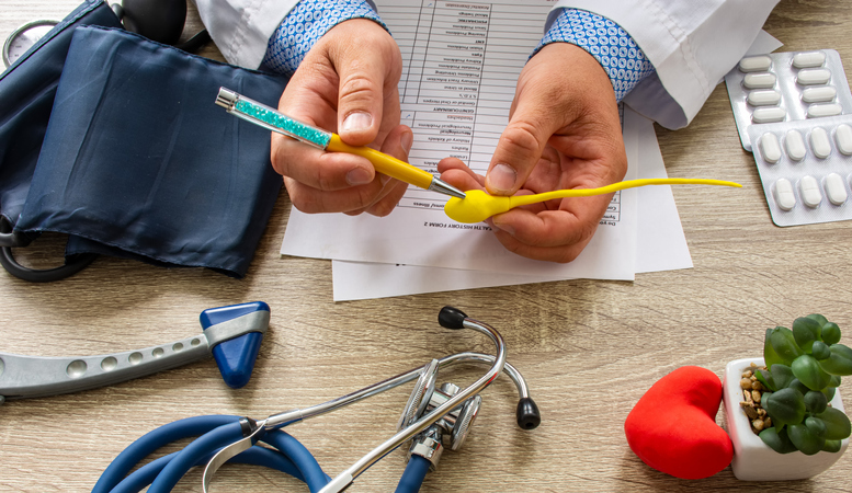 Doctor during consultation held in his hand and shows patient anatomical model of male sperm. Counseling of men and couples about male infertility, sperm pathology, impossibility to get pregnant, vasectomy.