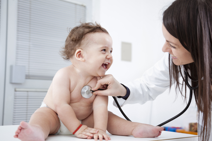 Doctor checking up baby with stethoscope, discussing hypospadias.