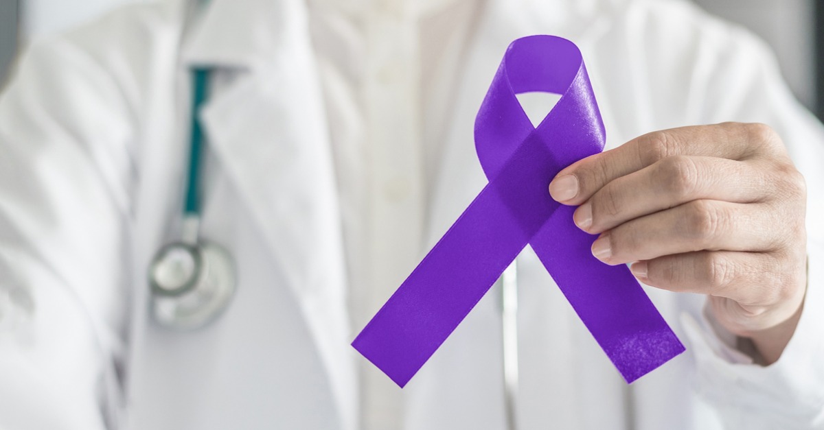 Doctor holding a purple ribbon for Testicular cancer.